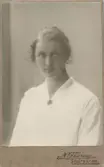 Ateljéporträtt av Ester Jakobsson (1896-1926). Ester var fosterdotter till Anton och Maria Gustafsson, Lilla Vommedal. Hon var också syster till Oscar Jakobsson (1889-1945), skaparen av den folkkäre seriefiguren Adamson*. Esther avled i TBC 1926.