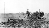 Lantarbetare kör traktor på Karlslunds herrgård, 1930-tal