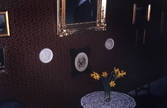 Vas med påskliljor vid tavelvägg i Karlslunds herrgård, 1980-tal