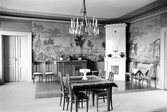 Mindre matbord under kristallkrona i rum med kakelugn och vävda tapeter i Karlslunds herrgård, 1981