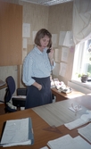 Kvinna talar i telefon vid skrivbord i Tysslinge, 1990