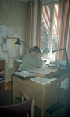 Kvinna vid skrivbord på kommunkontoret i Tysslinge, 1990