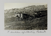 Vykort på stenhus och två hästdragna kärror i Sterling i Colorado, 1913
