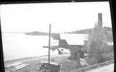 Utsikt över sjö, väg och fabriksbyggnad i Lennartsfors.