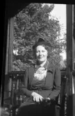 Porträtt av Ingrid Sundling sittandes på veranda.