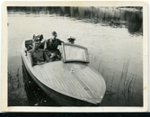 Tre män med uniform i båt, Haralnd Sundling till höger.