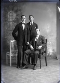 Ateljébild. Tre unga män i helfigur där en sitter. Möjligen är de barberare. Beställare: Oscar Schönbeck, Erikssons Frisersalong. Falkenberg.