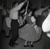 Bild tagen i samband med flyktingar ifrån Ungern kom 1956. Folk som dansar i förmodlingen Godtemplargården i Borgholm. Kvinnorna dansar i traditionella romska folkträkter. Hösten 56 - våren 57.