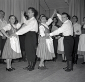 Bild tagen i samband med flyktingar ifrån Ungern 1956. Folk som dansar i förmodlingen Godtemplargården i Borgholm. Kvinnorna dansar i traditionella romska folkträkter. Hösten 56 - våren 57.