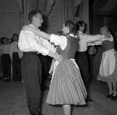 Bild tagen i samband med flyktingar ifrån Ungern 1956. Folk som dansar i förmodlingen Godtemplargården i Borgholm. Kvinnorna dansar i traditionella romska folkträkter. Hösten 56 - våren 57.