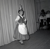 Bild tagen i samband med flyktingar ifrån Ungern 1956. En kvinna på scen i traditionell romsk folkdräkt i Godtemplargården hösten 56 - våren 57.