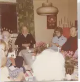 Personal och boende sitter och fikar i Brattåshemmets terapirum på nedre våningen, 1970-tal. Namnuppgifter saknas. I blå rock sitter en kvinnlig personal.