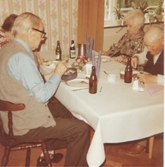 Fyra personer sitter vid ett bord och äter mat, Brattåshemmet 1970-tal. Från vänster: 1. Per Pettersson (1896 - 1981). 2. Skymd person. 3. Ellen Hansson, som har arbetat på Kålleredshemmet. 4. Alfred Mattsson (1895 - 1982).