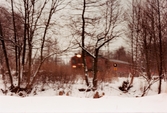 Ett tåg passerar Grevedämmet i Mölndal, januari 1984.