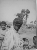 Abessininen 1936. 2 barn och 2 vuxna varav den ena vuxne håller en Läkerolask i plåt.