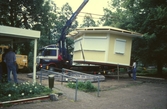 Kranbil lyfter serveringsbyggnaden på plats i Stadsparken, 1988