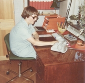 En föreståndare (namnuppgift saknas) sitter på sitt kontor, Brattåshemmet 1970-tal.