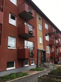 Husfasad med balkonger och port till bostadshuset med adressen Hagåkersgatan 14C i Bosgården, Mölndal, år 2019.