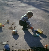Lekande pojke med hink i sandlåda, 1960-tal