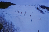 Många skidåkare i backen, 1970-tal