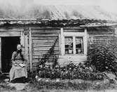 Dammsjö-Lotta utanför sin stuga, 1880-tal