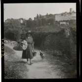 1950. Frankrike. En kvinna går längs med en stig med hund