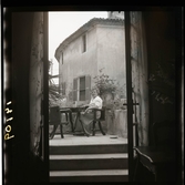 1950. Frankrike. Kvinna sitter på terrass