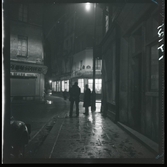 1950. Frankrike. Kvällsbild, två män på gata