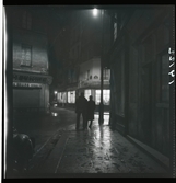 1950. Frankrike. Kvällsbild, två män på gata