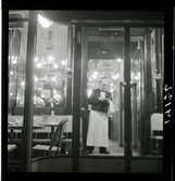 1950. Paris. Hovmästare ses från fönster sett från gatan