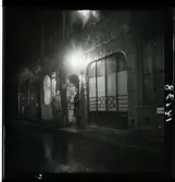 1950. Paris. Två män stående på gata kvällsbild.