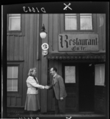 511 Gripsholms Slott för Allers. En kvinna och en man skakar hand framför en skylt för Restaurant.