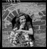 511 B Gripsholms Slott. En kvinna med en korg blommor i ett litet fönstervalv.