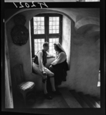 511 B Gripsholms Slott. Ett par i folkdräkter sitter tillsammans vid ett fönster.