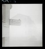 542 Dimma. En frisör-skylt på fasad på Margaretelundsvägen i dimma.