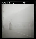 542 Dimma. Trafikpolis står i sin kur i en dimmig korsning.