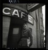 558 Wilhelm Moberg. Vilhelm Mobergn i uniform, påväg in i ett café.