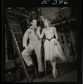 561 Operan för Allers. En kvinnlig dansare i kostym och en man i arbetare-overall, bakom kulisserna.