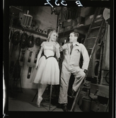 561 Operan för Allers. En kvinnlig dansare i kostym och en man i scenarbetare-overall, bakom kulisserna.