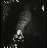561 Operan för Allers. En kvinna sitter bakom kulisserna framför scendekor och läser manus.