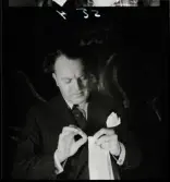 568 Trenters reportage. En man utför trolleri-trick med näsduk och tändsticka.