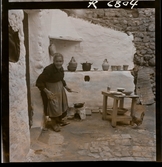 568 F. Stieg Trenter, Torremolinos. En äldre kvinna lagar mat utanför sitt hus.