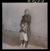 568 F. Stieg Trenter, Torremolinos. En äldre kvinna och en flicka vid en husvägg.