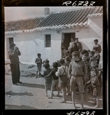 568 F. Stieg Trenter, Torremolinos. Stieg Trenter fotograferar en grupp invånare och barn i byn.