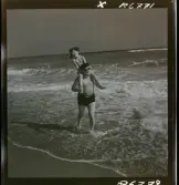 568 F. Stieg Trenter, Torremolinos. Stieg Trenter bär sin dotter på sina axlar i vattenbrynet.