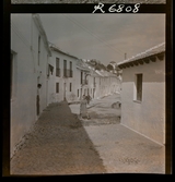 568 F. Stieg Trenter, Torremolinos. En kvinna kommer gåendes på en gata i byn.