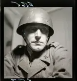 581 Bokomslag militärt. Porträtt av militär i uniform, hjälm.