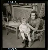 583 Sickan Carlsson för 25an Allers. Sickan Carlsson sitter i en fåtölj med en liten flicka i knät.