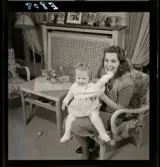 583 Sickan Carlsson för 25an Allers. Sickan Carlsson sitter i en fåtölj med en liten flicka i knät.