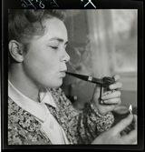 584 Brunsviks Folkhögskola. En ung kvinna röker pipa.